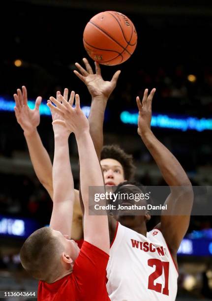 Khalil Iverson of the Wisconsin Badgers attempts a shot while being guarded by Thorir Thorbjarnarson of the Nebraska Huskers in the second half...