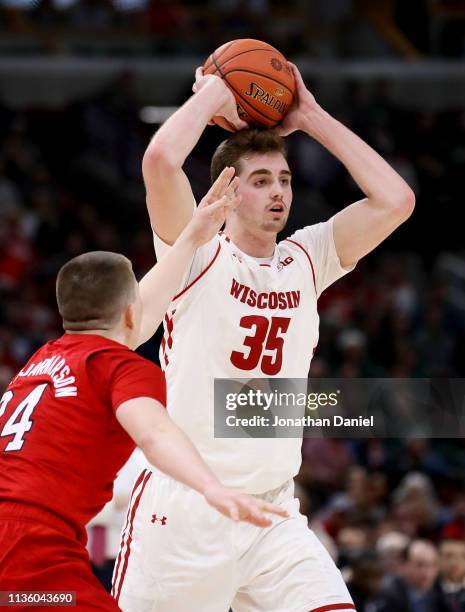 Nate Reuvers of the Wisconsin Badgers handles the ball while being guarded by Thorir Thorbjarnarson of the Nebraska Huskers in the second half during...