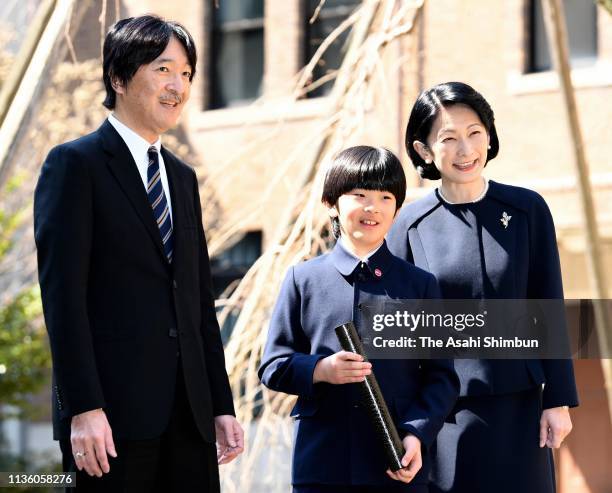 Prince Hisahito poses for photographs with his parents Prince Akihito and Princess Kiko of Akishino after attending the graduation ceremony of...