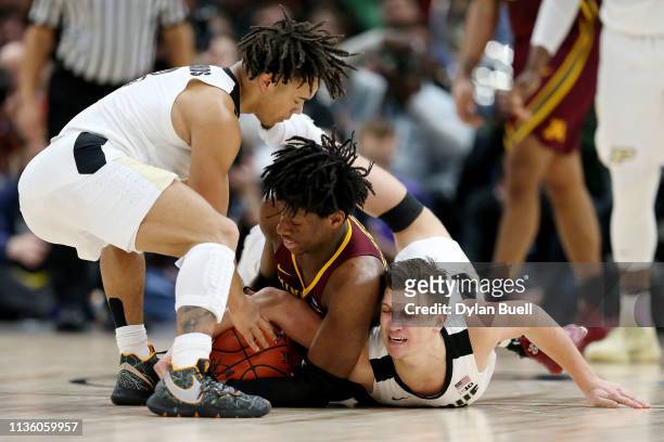 Daniel Oturu of the Minnesota Golden Gophers battles for a loose ball against Carsen Edwards and Grady Eifert of the Purdue Boilermakers in the first...