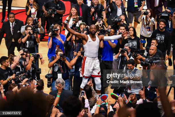 Dwyane Wade of the Miami Heat runs on top of the scorers table to thank the fans after the final regular season home game of his career against the...
