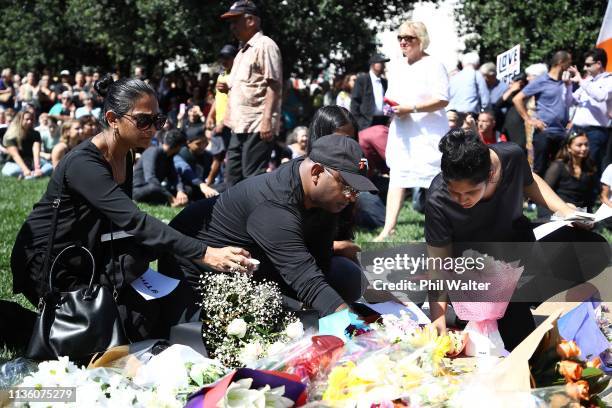 People place flowers and messages of condolence as a large crowd gathers in Aotea Square for a memorial to remember the victims of the Christchurch...