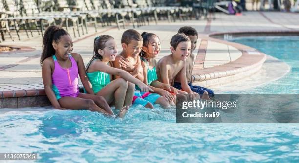 multi-ethnic group of children on side of swimming pool - boy-with-a-girl-playing-at-the-poolside stock pictures, royalty-free photos & images