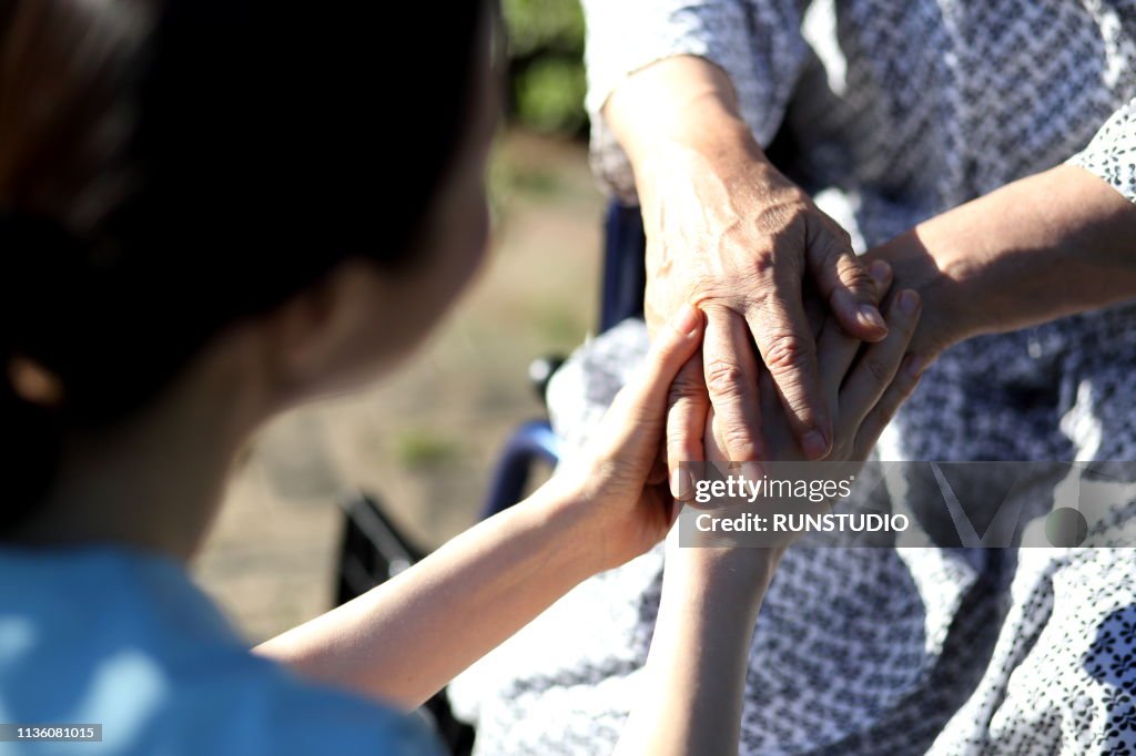 Close up of nurse holding senior man's hands