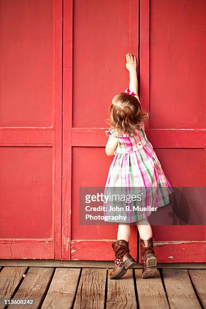 cowgirl on a red door - child raised arms age 3 stock pictures, royalty-free photos & images