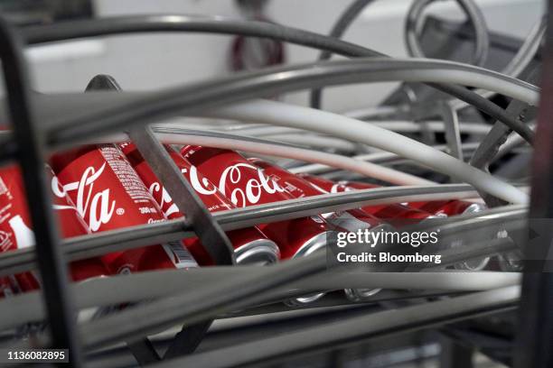 Cans move along a conveyor before being filled with Coca-Cola Co. Brand Coke carbonated soft drink at the Moon Beverages Ltd. Coca-Cola Happiness...