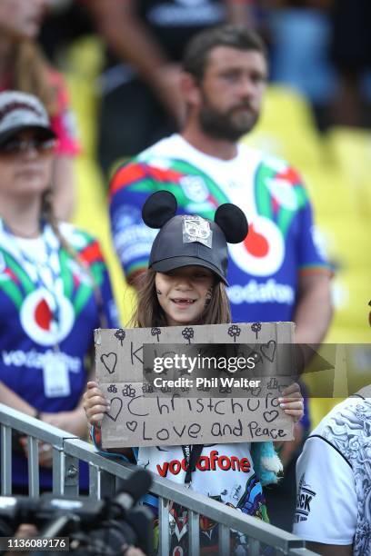 Fan holds a sign for the victims of the Christchurch mosque shootings during the round 1 NRL match between the New Zealand Warriors and the...