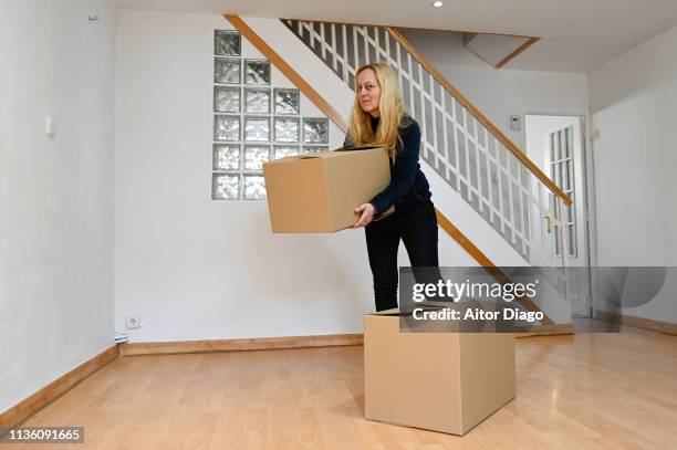 Woman Looking At Camera With A Cardboard Box In Her New House Moving High-Res Stock Photo