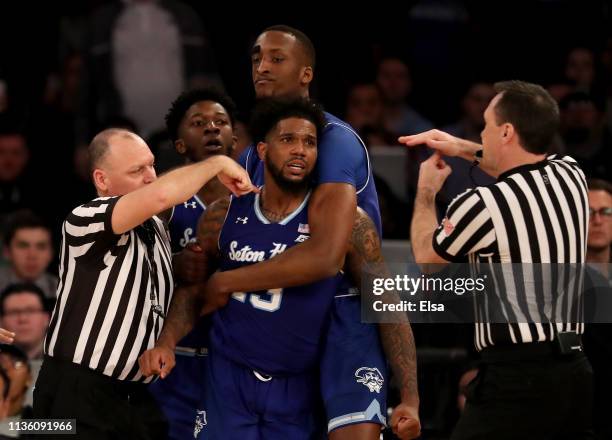 Romaro Gill of the Seton Hall Pirates holds back teammate Myles Powell as he is given a technical during an altercation with Marquette Golden Eagles...