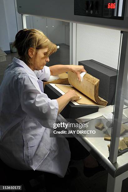 German conservator Monika Scheneider-Gast restores the century-old book titled "El Filibusterismo" at the National Library in Manila on May 4, 2011....