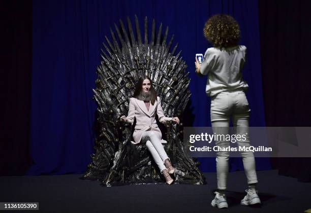 Invited guests pose on the Iron Throne at the Game Of Thrones: The Touring Exhibition launch at Titanic Exhibition Centre on April 10, 2019 in...
