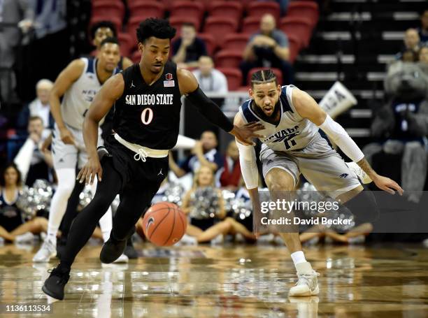 Devin Watson of the San Diego State Aztecs and Cody Martin of the Nevada Wolf Pack chase a loose ball during a semifinal game of the Mountain West...