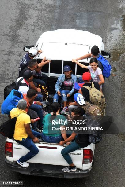 Honduran migrants ride in the back of a pickup truck as they leave the Metropolitan Center of San Pedro Sula, 300 kms north of Tegucigalpa, to travel...