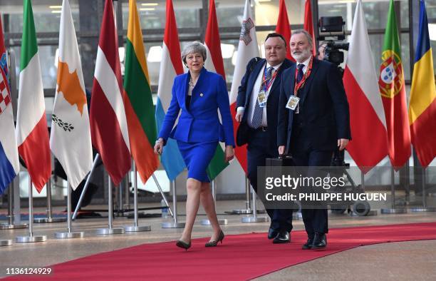 Britain's Prime Minister Theresa May , flanked by British Ambassador to the EU Tim Barrow , arrives ahead of a European Council meeting on Brexit at...