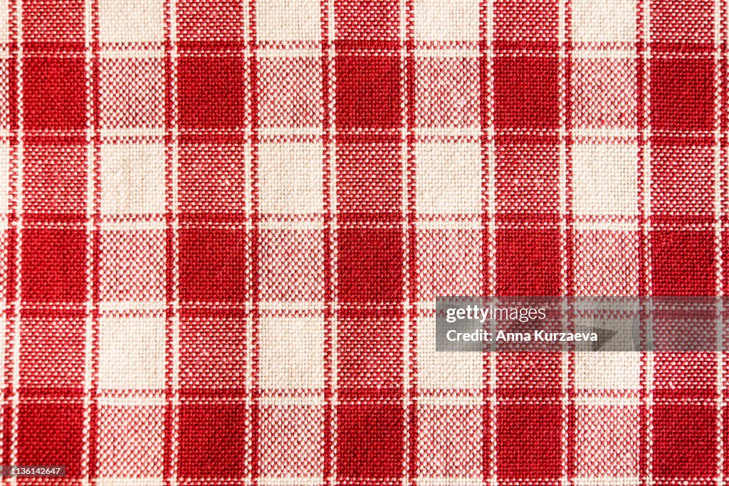 Textile background with a checkered red napkin, top view. Natural textile background. Fabric texture background. Texture of natural linen fabric.
