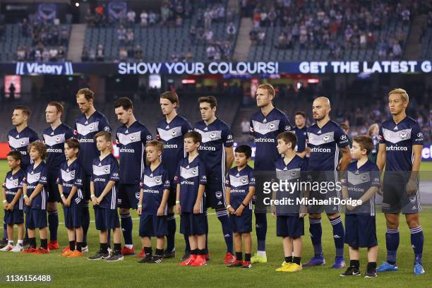 Brisbane Roar and Melbourne Victory players stand for a minutes silence in tribute to the Christchurch Mosque terror attack on March 16, 2019 in...