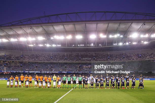 Brisbane Roar and Melbourne Victory players stand for a minutes silence in tribute to the Christchurch Mosque terror attack on March 16, 2019 in...