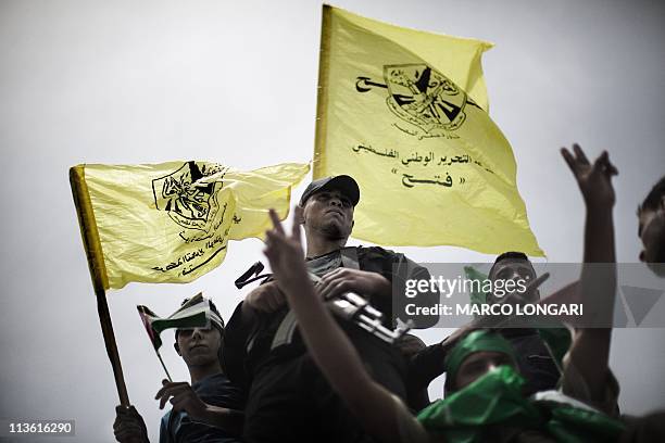 Hamas policeman © stands on top of the Unknown Soldier monument with young Gaza residents celebrating the unity deal in a demonstration in Gaza City...