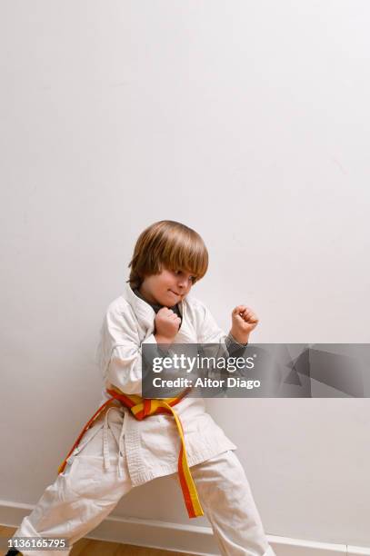 small child with fists of hands closed in fight attitude doing karate - child judo stock pictures, royalty-free photos & images