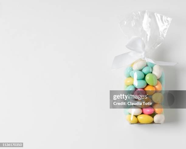 chocolate covered almonds in cellophane wrap on white background - celofán fotografías e imágenes de stock