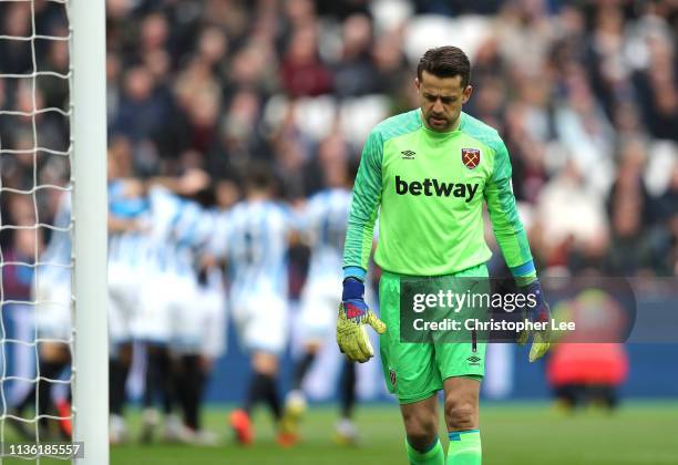 Lukasz Fabianski of West Ham United reacts after Juninho Bacuna of Huddersfield Town scores his team's first goal during the Premier League match...