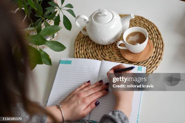 woman writing her notebook - picture book stock pictures, royalty-free photos & images