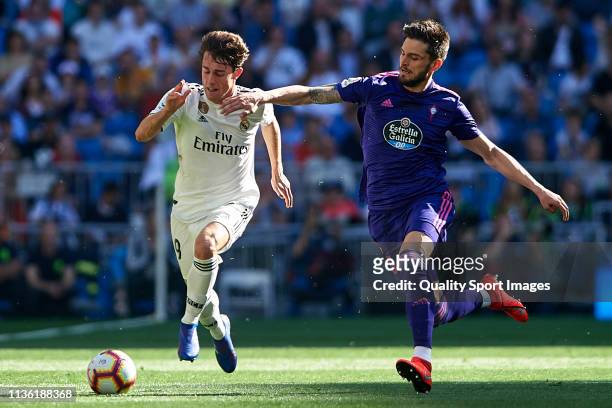 Alvaro Odriozola of Real Madrid competes for the ball with Okay Yokuslu of RC Celta de Vigo during the La Liga match between Real Madrid CF and RC...