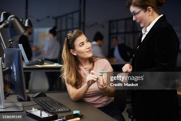 creative businesswoman discussing with bank manager over solar toy car in creative office - private equity stock pictures, royalty-free photos & images