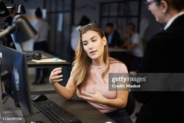 creative businesswoman explaining bank manager at desk in creative office - private equity stock pictures, royalty-free photos & images