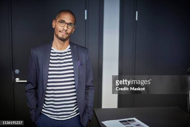 portrait of confident creative businessman standing in office - casual chic foto e immagini stock