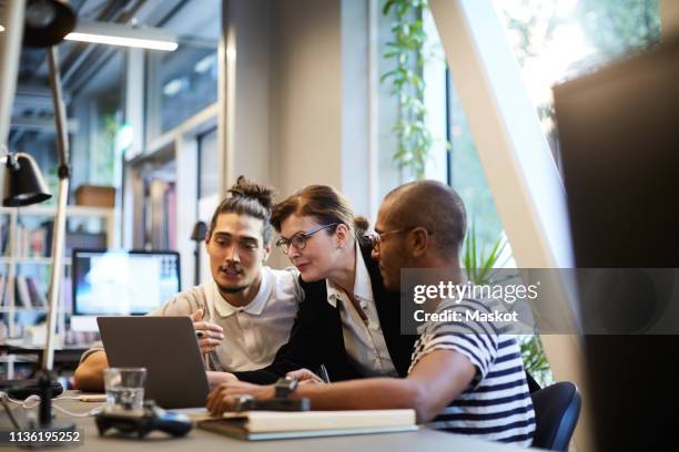 male entrepreneurs explaining female bank manager over laptop at desk in creative office - private equity stock pictures, royalty-free photos & images