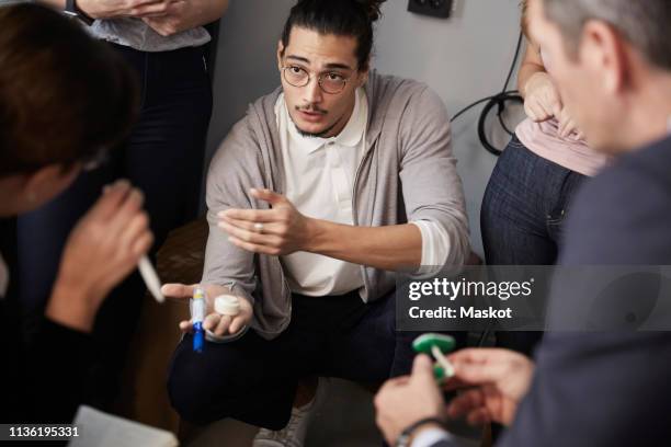 male entrepreneur explaining project to bank managers during meeting in creative office - private equity stock pictures, royalty-free photos & images