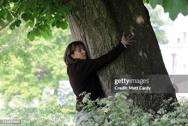 Woman hugs a tree in the grounds of Glastonbury Abbey as she enjoys the apple blossom and other flowering trees on May 4, 2011 in Glastonbury,...