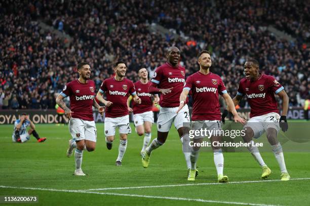 Javier Hernandez of West Ham United celebrates after scoring his team's fourth goal with his team mates during the Premier League match between West...