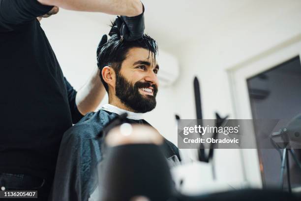 young stylish barber with mustache and tattoos giving man haircut - cutting hair stock pictures, royalty-free photos & images