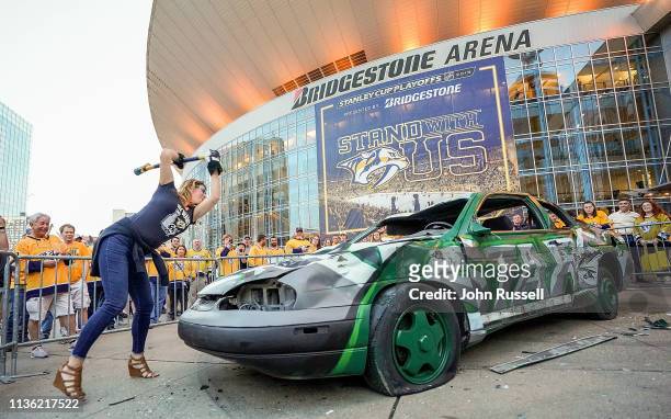 Nashville Predators fan swings a hammer on the Dallas Stars smash car outside Bridgestone Arena prior to Game One of the Western Conference First...