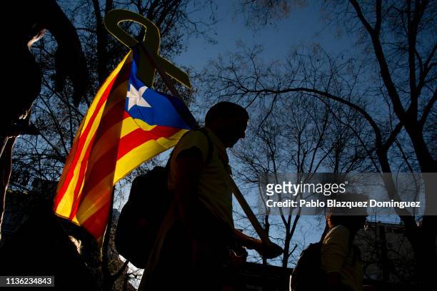 Protester carries a Catalan Independence flag and a yellow ribbon during a demonstration titled 'Self-determination is not a crime' on March 16, 2019...