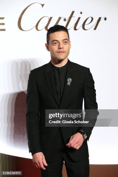 Rami Malek wearing the watch "Santos" by Cartier during the Clash de Cartier event at la Conciergerie on April 10, 2019 in Paris, France.