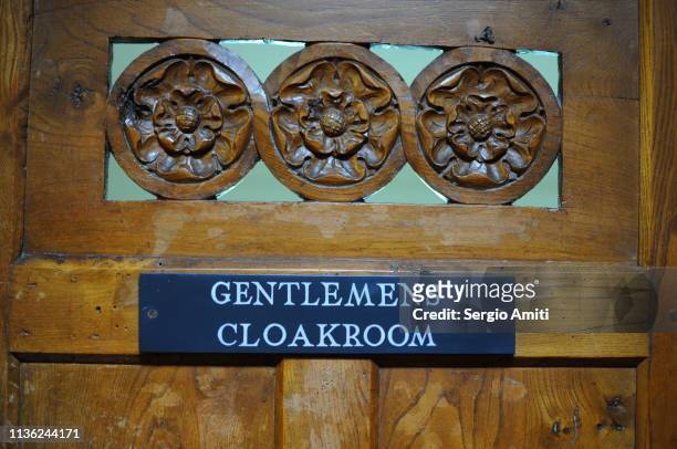 gentlemens cloakroom sign on wooden door - rechtschreibfehler stock-fotos und bilder