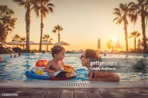 niño con madre en la piscina, resort de vacaciones - family and leisure fotografías e imágenes de stock