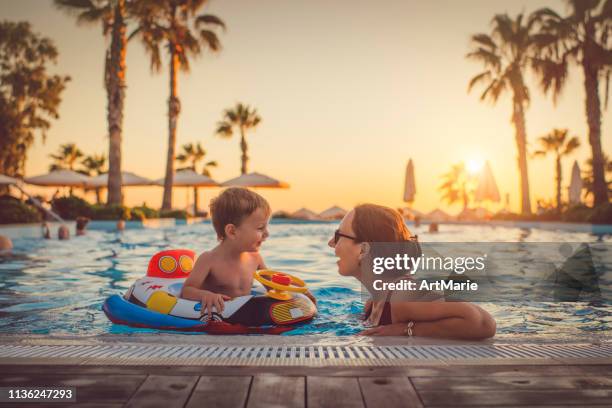 enfant avec la mère dans la piscine, station de vacances - station de vacances photos et images de collection
