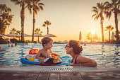 Child with mother in swimming pool, holiday resort