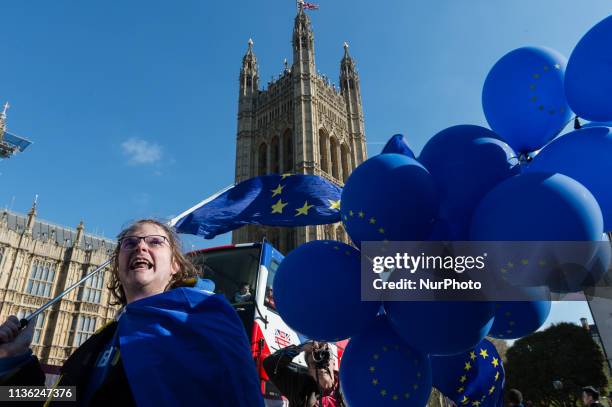 An anti-Brexit demonstrator holds blue balloons with EU symbols during a protest outside the Houses of Parliament on 10 April, 2019 in London,...