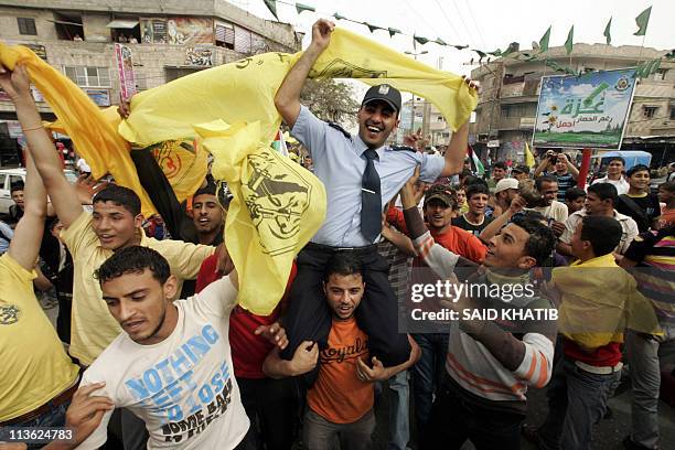 Palestinian Hamas policeman holds the Fatah flag as he joins celebrations marking the political reconciliation agreement between rival Palestinian...