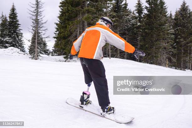 amputee snowboarder with prosthetic leg - disabled extreme sports stock pictures, royalty-free photos & images