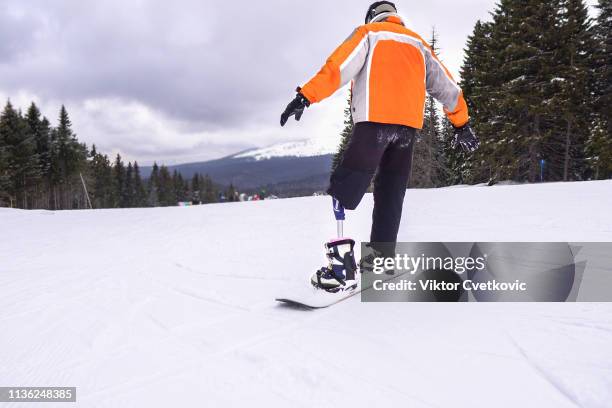 amputee snowboarder with prosthetic leg - disabled extreme sports stock pictures, royalty-free photos & images