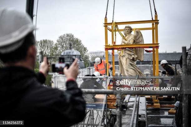 Workers man the re-installation of restored angel sculpture on the dome of the Notre-Dame du Val-de-Grace church in central Paris on April 10, 2019. -