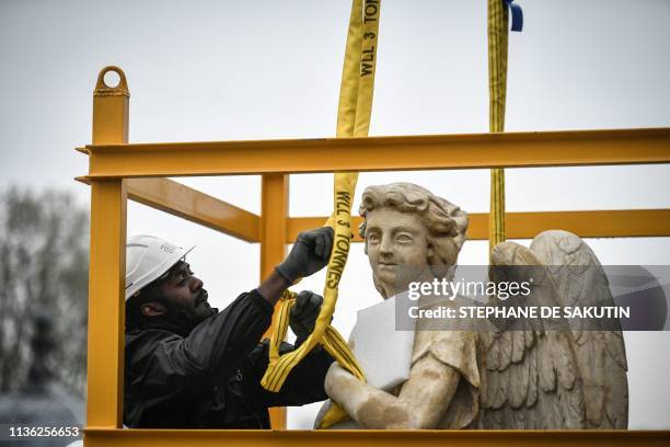 Workers mans the re-installation of restored angel sculpture on the dome of the Notre-Dame du Val-de-Grace church in central Paris on April 10, 2019....