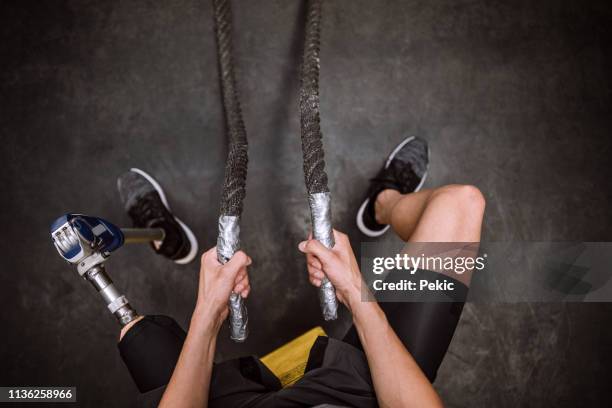 amputee athlete doing battle rope exercises - prosthetic leg stock pictures, royalty-free photos & images