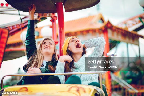 we gonna have fun at amusement park - young woman screaming on a rollercoaster stock pictures, royalty-free photos & images